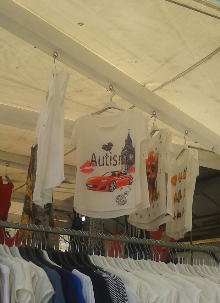 T-shirts hanging at a market stall featuring random prints, showcasing hilarious fashion fails in design choices.