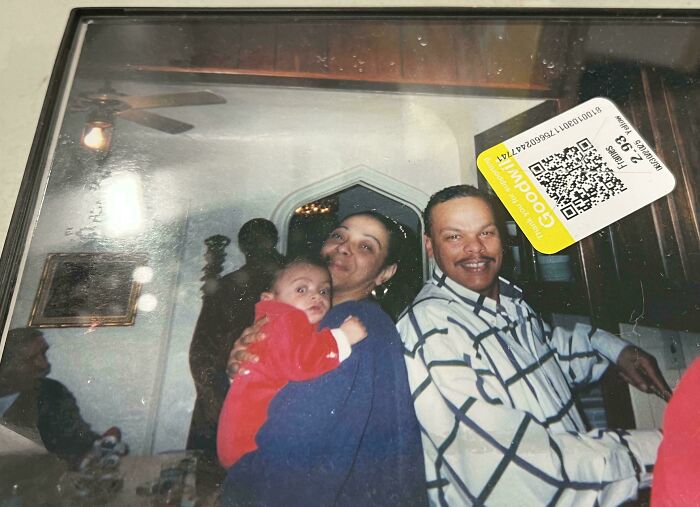 Family photo of parents and baby indoors, with shadowy figure in background, evoking scary posts shared online.