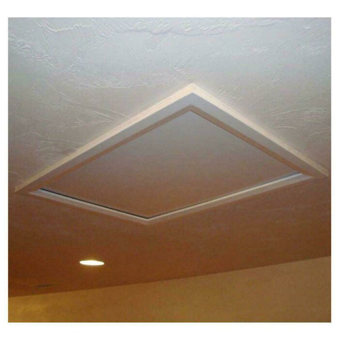 Ceiling panel with a recessed light nearby, creating a strange and eerie visual effect in the space.