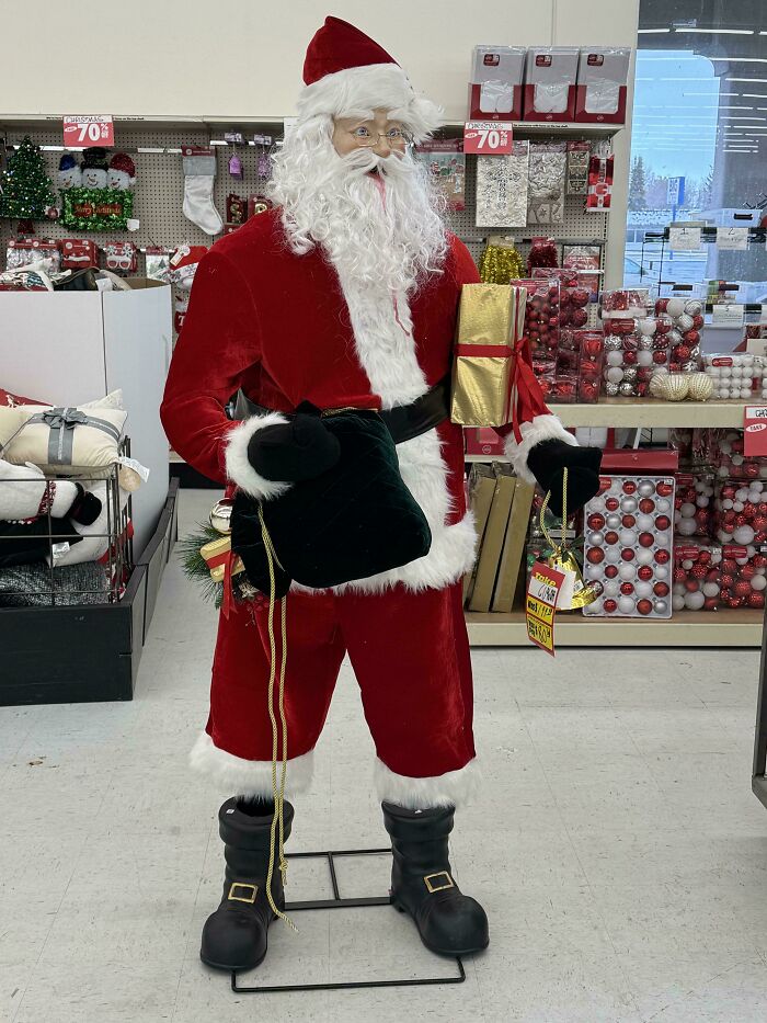 Life-size Santa figure with a creepy face holding gifts inside a holiday store, one of the scariest posts shared online.