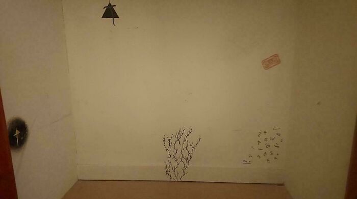 Empty room corner with dark creepy drawings on walls, fitting the theme of scary posts shared online.