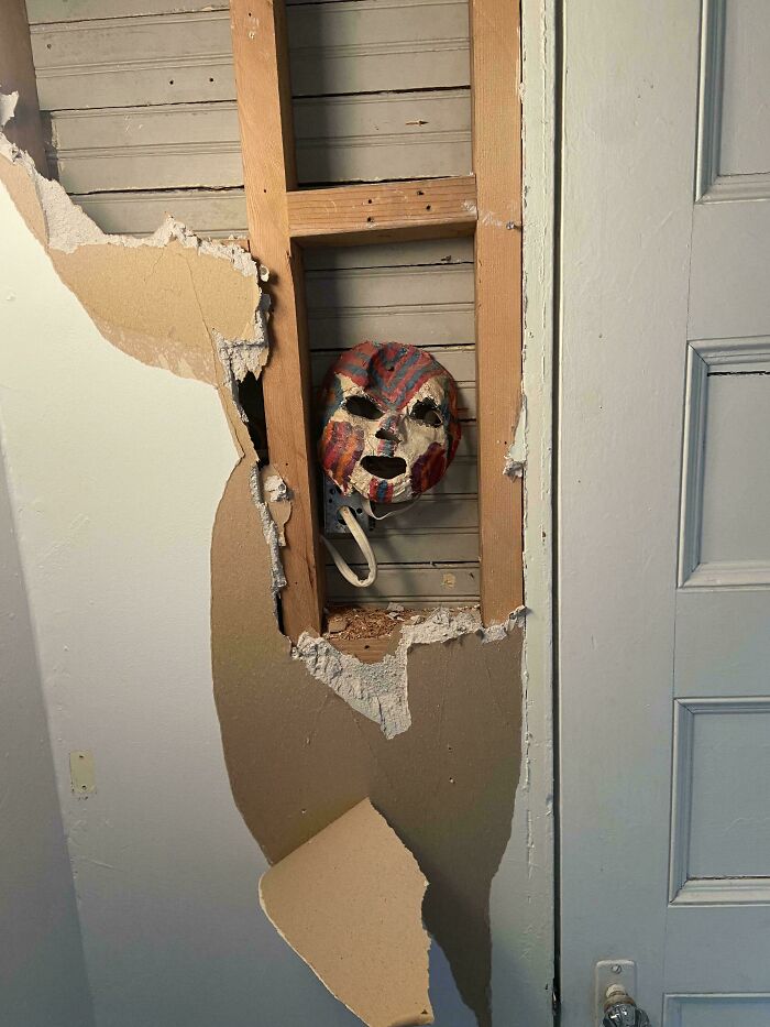 Creepy colorful mask hidden inside a broken wall cavity, creating one of the scariest posts shared online.
