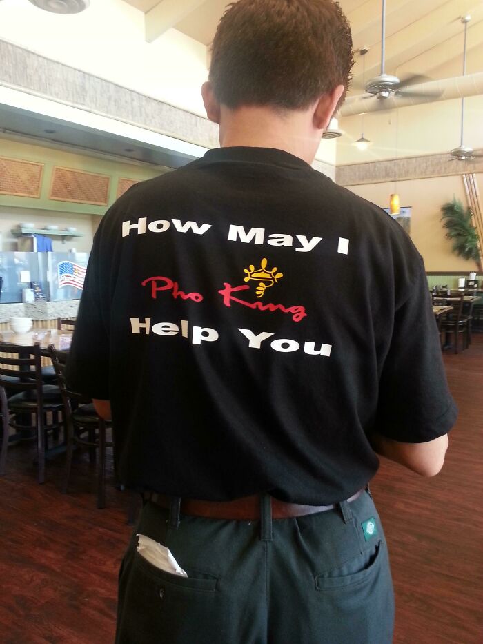 Man wearing a black shirt with a humorous typo, a classic example of hilarious fashion fails in a casual restaurant setting. Man wearing a black shirt with a humorous typo, a classic example of hilarious fashion fails in a casual restaurant setting.