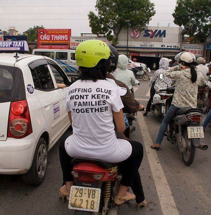 Person wearing a funny t-shirt with a message, sitting on a motorcycle in traffic, showcasing hilarious fashion fails. Person wearing a funny t-shirt with a message, sitting on a motorcycle in traffic, showcasing hilarious fashion fails.