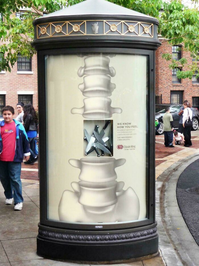 Print advertisement using creativity and humor shows spine with knives to highlight pain relief services outdoors.