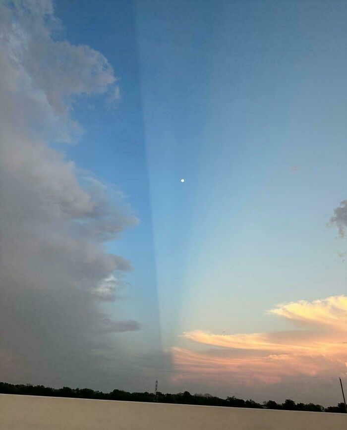 Sunset sky split by a sharp vertical beam with moon and clouds, surreal glitches in the matrix scene.