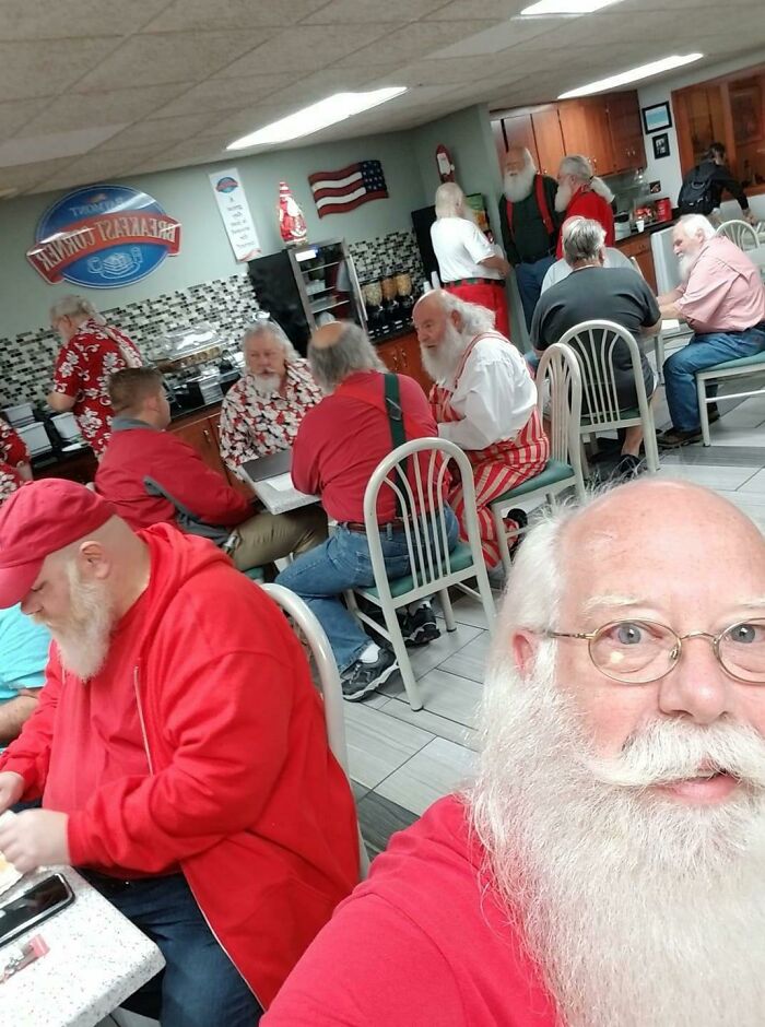 Several bearded men dressed as Santa in a diner, many look identical, glitches in the matrix