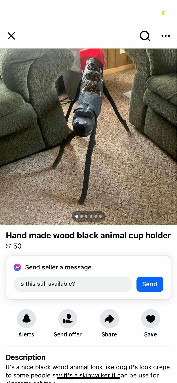 Handmade black wooden animal cup holder shaped like a long-legged dog on carpet between couches, odd item to sell online