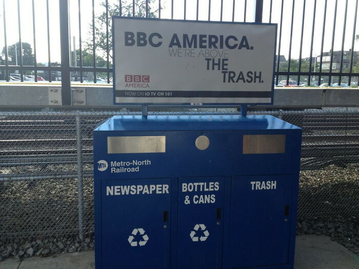 Creatively humorous print advertisement by BBC America placed above a trash bin at a train station emphasizing being above the trash.