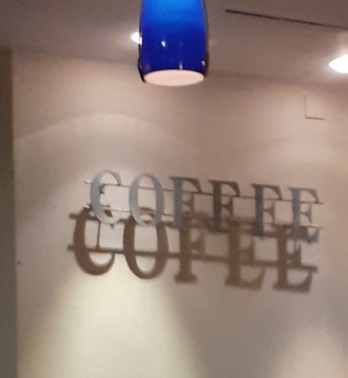 Coffee sign casting doubled shadow under blue lamp, a real-life glitches in the matrix moment