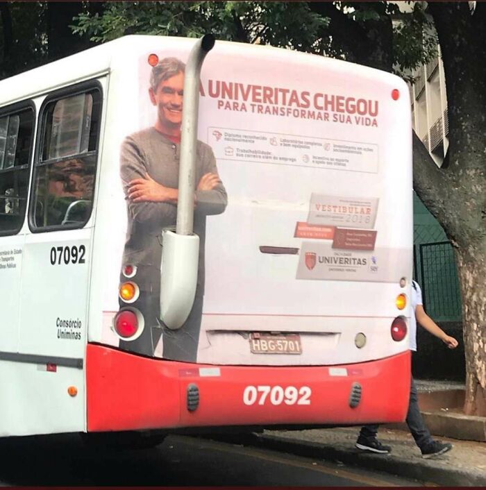 Bus with a creative print advertisement showing a man smiling, using humor and creativity to stand out from competitors.