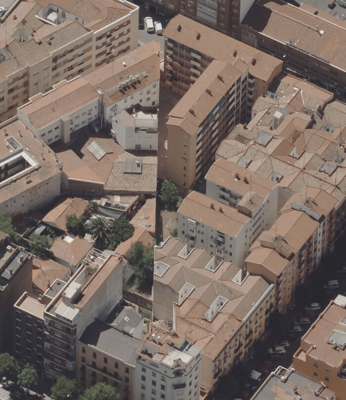 Aerial view of terracotta rooftops and narrow streets, suggesting glitches in the matrix