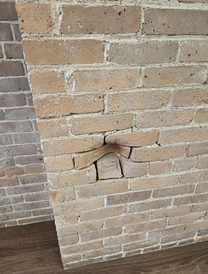 Glitches in the matrix: uneven brick wall with missing and displaced bricks forming a hole