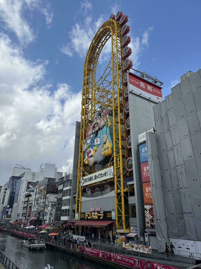 Roller coaster built into a city building over a canal, showcasing impressive things countries implemented in urban design.
