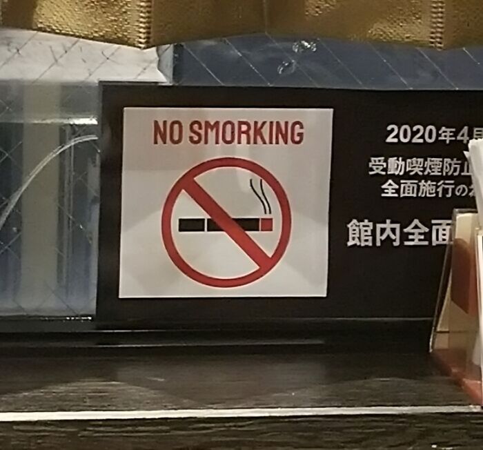 No smoking sign with misspelled text showing a funny Japan translation mistake to English in a public place.