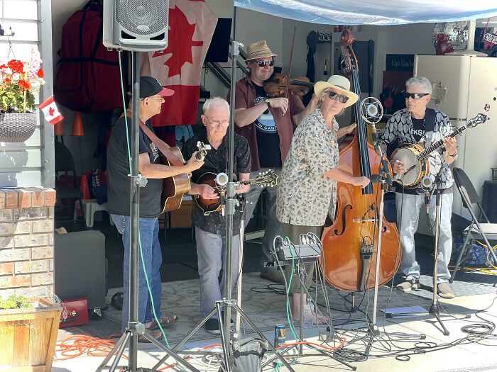 Live band performing outdoors with various string instruments, showcasing impressive things countries implemented in community events.