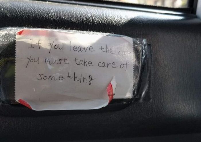 Handwritten humorous translation error from Japan taped inside a car door, showing a confusing English message.