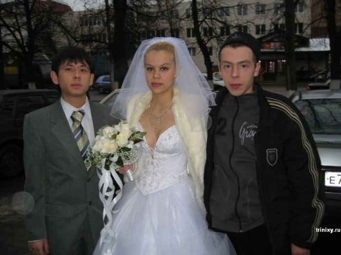 Bride in a wedding dress holding a bouquet standing between two men, an awkward wedding photo with unusual attire contrast