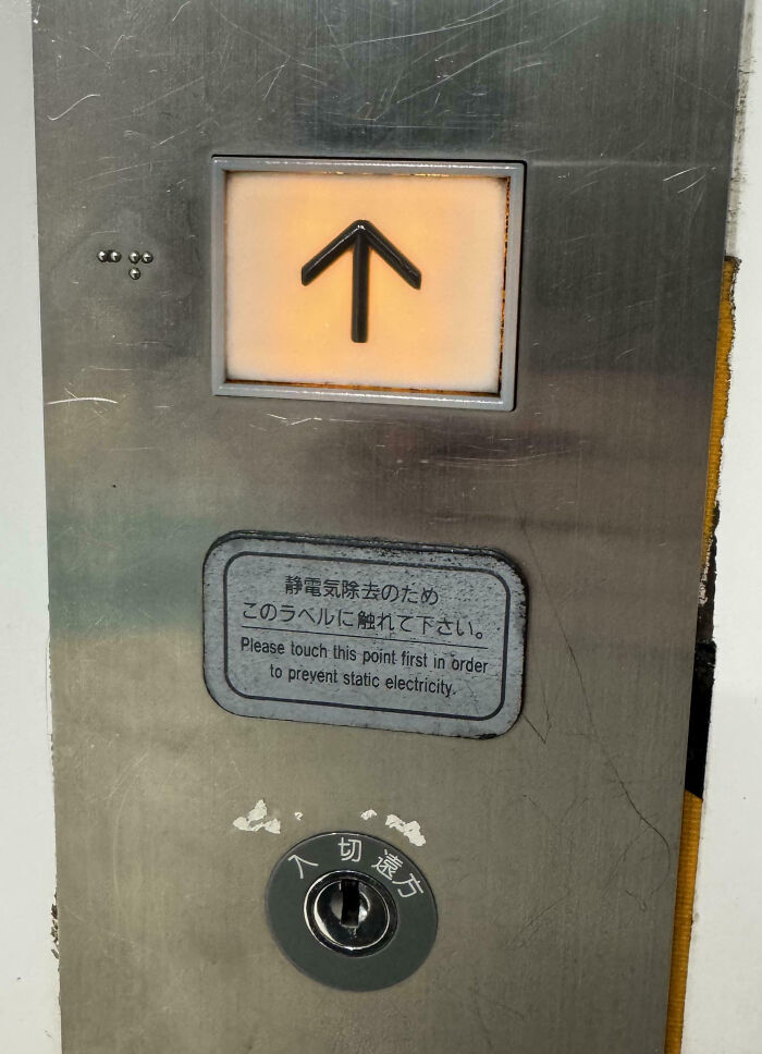 Elevator panel with an arrow and a static electricity prevention label, showcasing impressive things countries implemented.