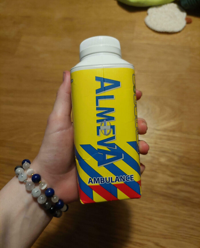 Hand holding a yellow bottle with blue and red stripes labeled ambulance, showcasing impressive things countries implemented.