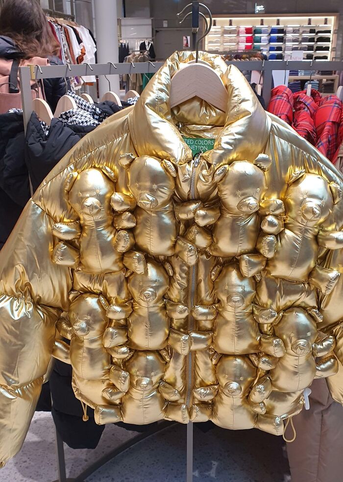 Gold puffer jacket adorned with multiple stuffed teddy bears hanging on rack, showcasing hilarious fashion fails.