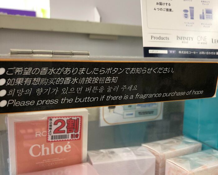 Sign with humorous English translation error about pressing a button for fragrance purchase, showing Japan translation mistakes.