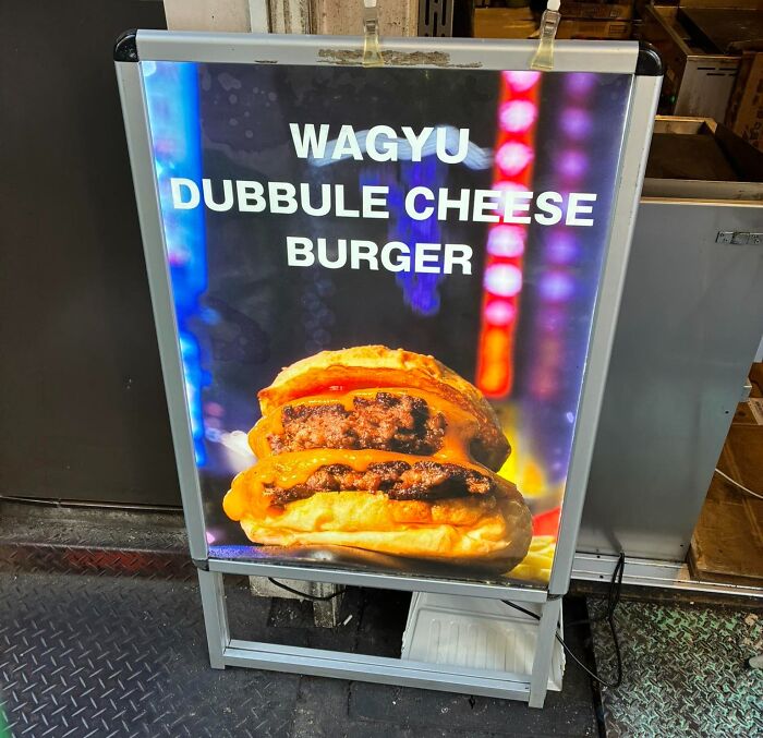 Signboard showing a humorous English translation error with the phrase dubbbule cheese burger in Japan.