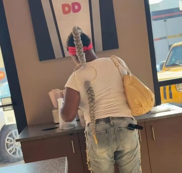 Mujer con un peinado ridículo trenzado largo que parece poco práctico para llevar un sombrero después.