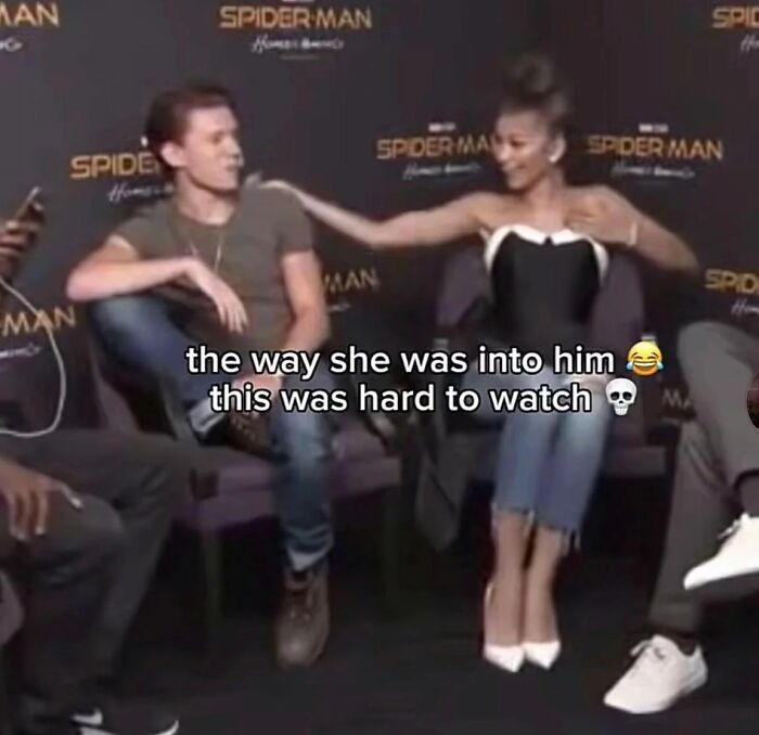 Two actors at a Spider-Man event share an awkward moment, one visibly uncomfortable, capturing a cringe-worthy pop culture moment.