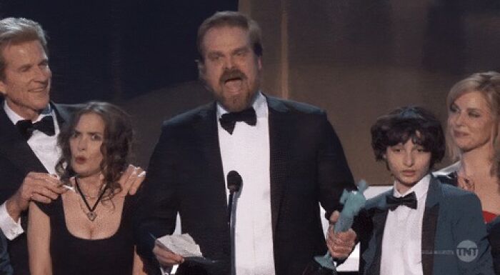 Group of actors on stage at an award show, capturing a pop culture moment that made people cringe hard.