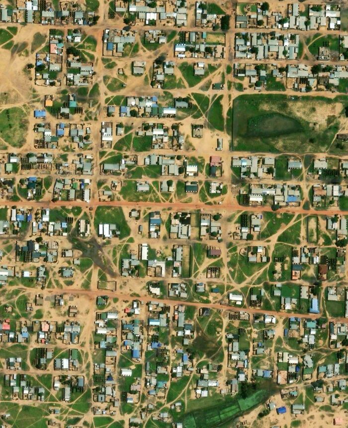 Aerial view of a city showing numerous desire paths where people walk off planned streets and sidewalks.