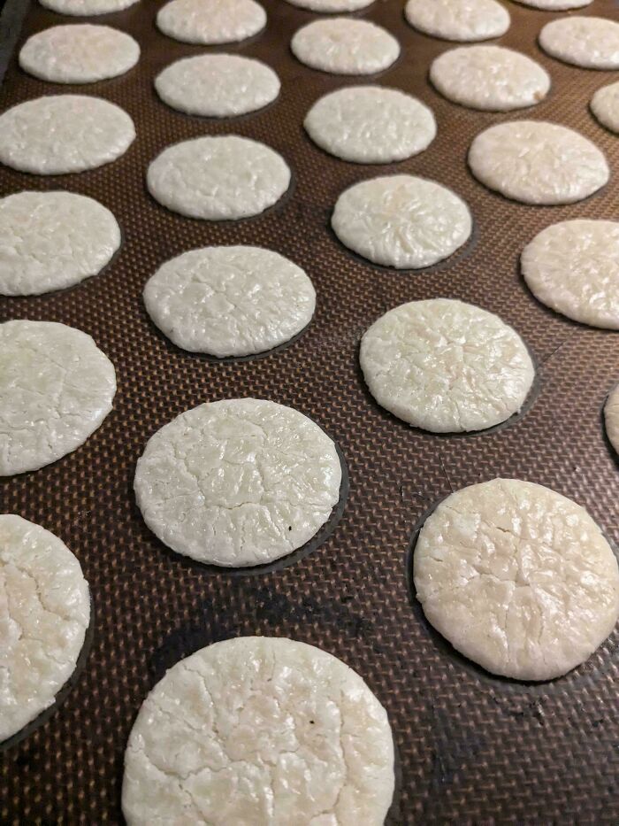 Flat, c*****d dessert cookies arranged in rows on a baking tray showcasing ways people managed to ruin dessert.