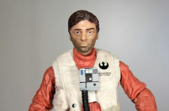 Clumsily designed offensive celebrity doll wearing a red outfit and white vest with a Star Wars insignia on a gray background.