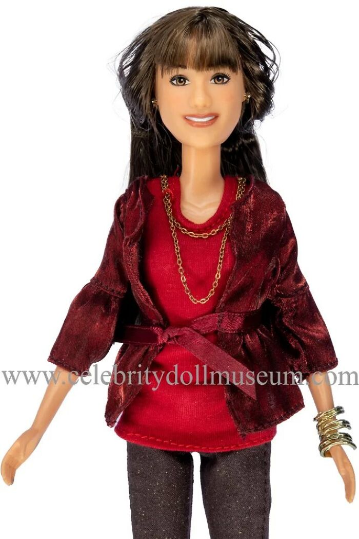 Celebrity doll wearing a red top and jacket with gold chains and bracelets, featured in offbeat celebrity dolls collection.