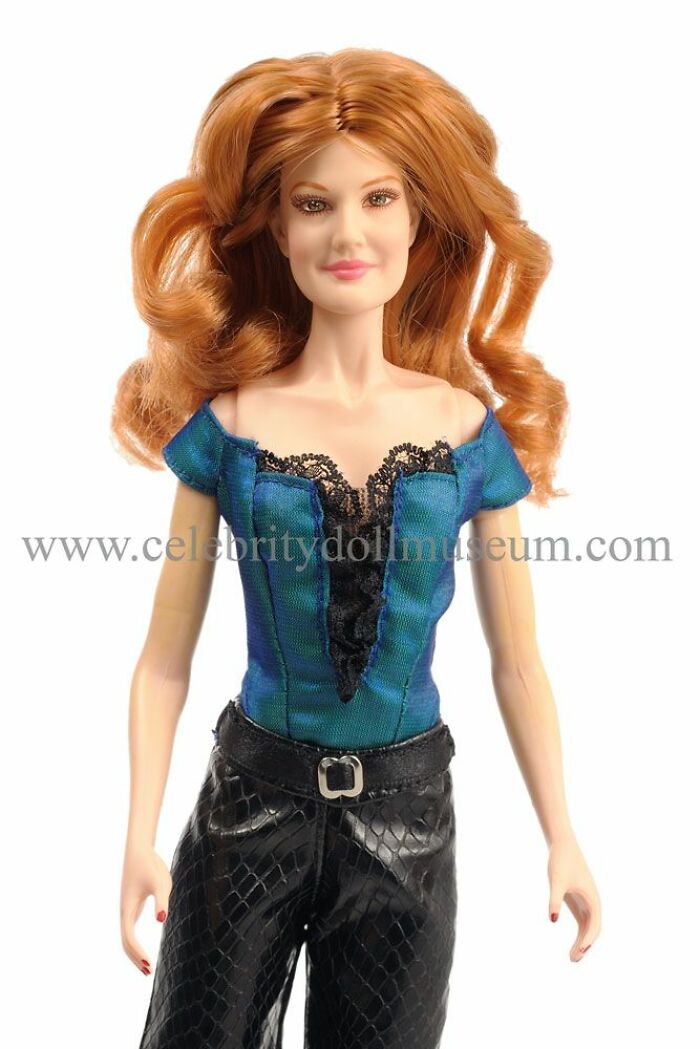 Red-haired celebrity doll with unrealistic features wearing blue top and black pants, part of offensively ugly celebrity dolls collection.