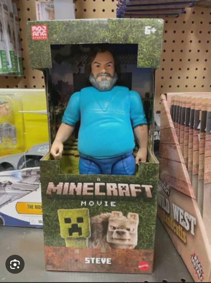 Offensively ugly celebrity doll of a Minecraft character Steve in a toy box on a store shelf among other toys.