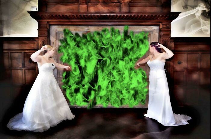 Two brides in wedding dresses pretending to cast spells with green flames in an awkward wedding photo.