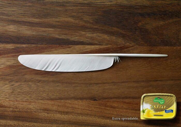 Feather shaped like a knife spreading butter, a creative print advertisement showcasing humor and creativity.
