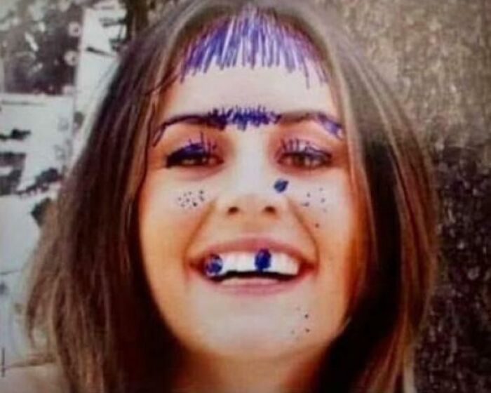 Young woman with ink drawings on her face, showing a playful moment that can make you feel old as heck.