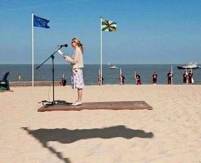 Woman reading on a beach with a shadow that looks like a flying carpet in a random and cringe photo for unique humor fans