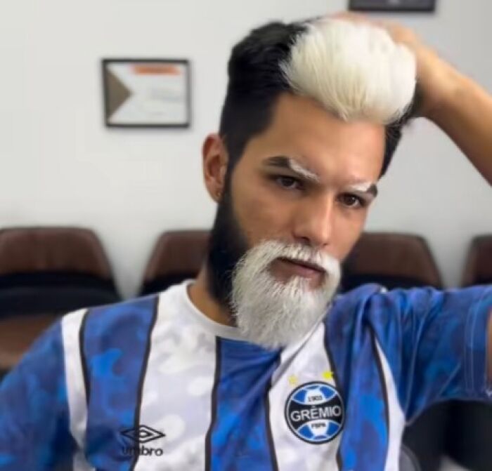 Hombre con peinado ridículo y barba blanca que parece un resultado inesperado de un corte de cabello original.