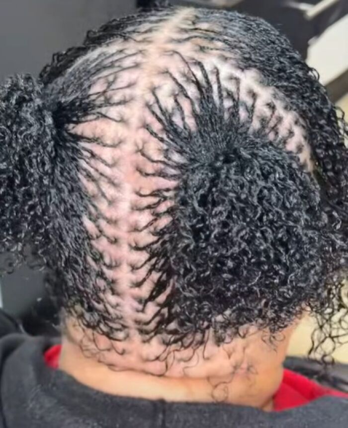 Peinado ridículo con trenzas desordenadas y mechones rizados que hacen querer usar un sombrero todo el año.