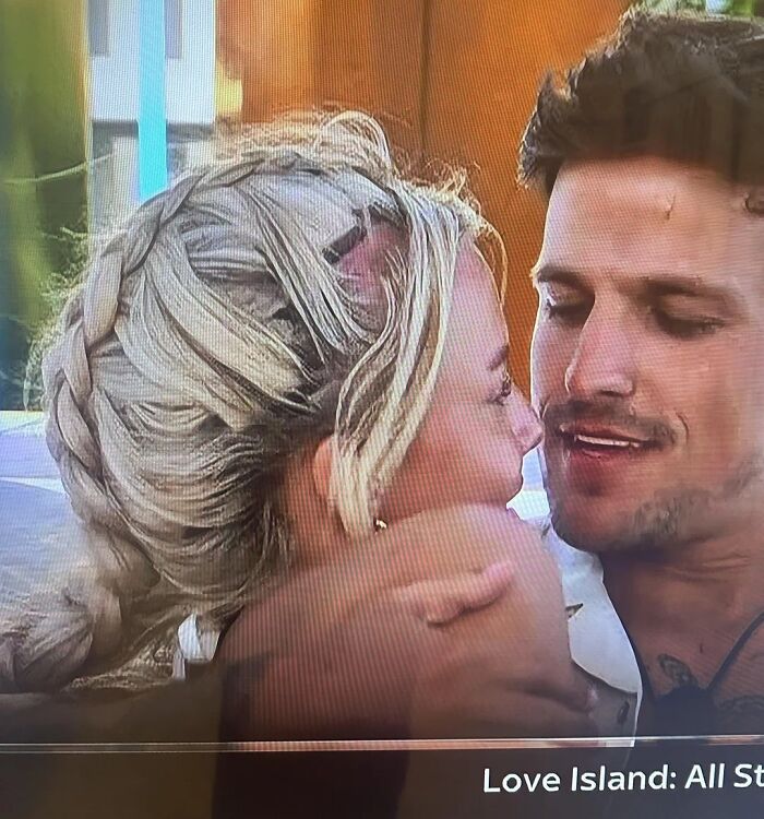 Pareja abrazándose con peinados ridículos que muestran la diferencia entre lo pedido y lo recibido en estilos de cabello.