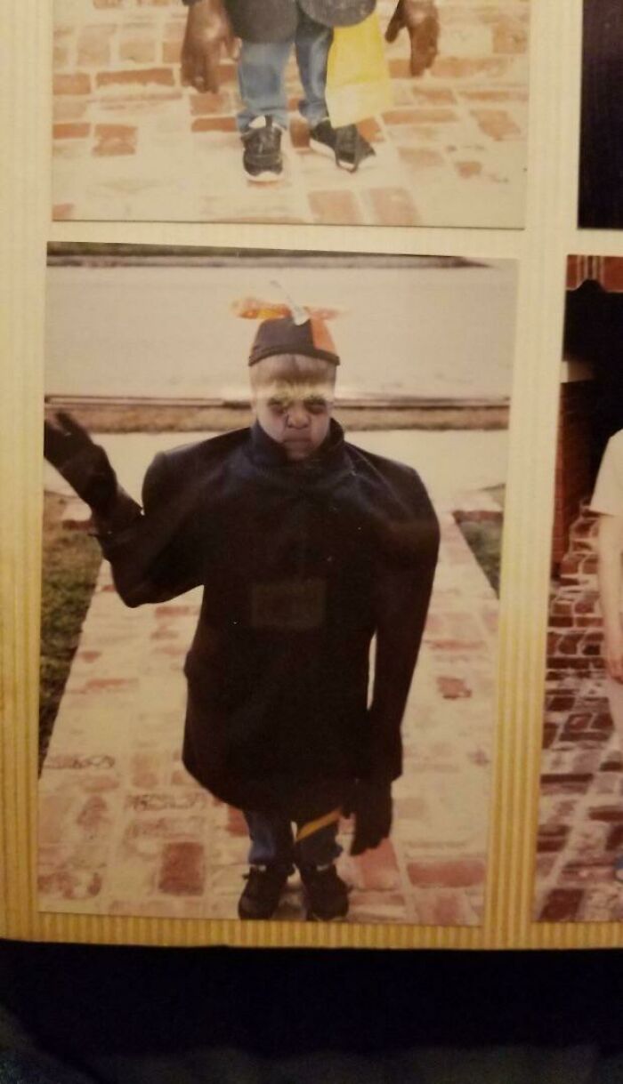 Creepy old-school photo of a child in a dark costume with distorted proportions, evoking a slightly cursed feeling.