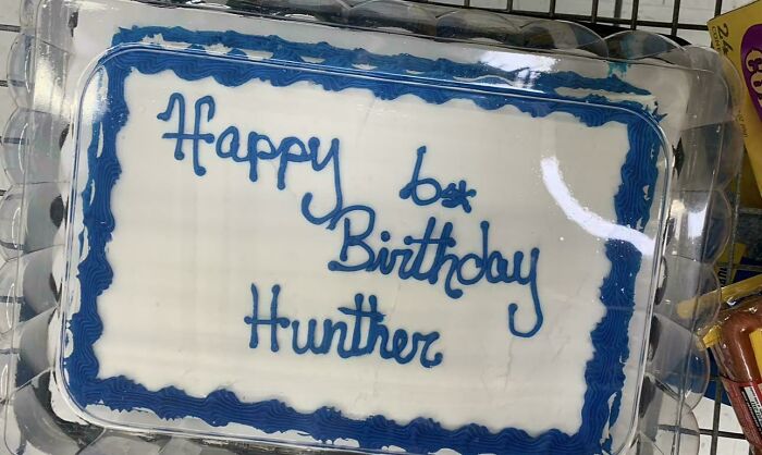 Birthday cake with misspelled message Happy Birthday Hunhter in a clear plastic container, reflecting funny cake mistakes.