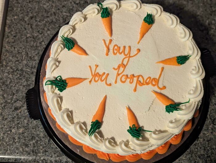Round white cake decorated with orange carrots and text reflecting funny cakes with honest emotions.