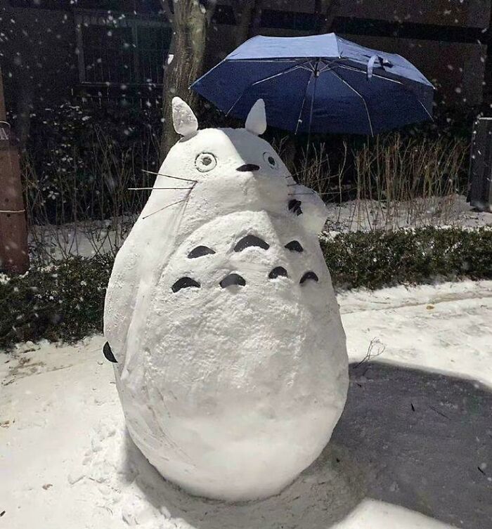 Muñeco de nieve en forma de Totoro sosteniendo un paraguas, imagen acogedora para disfrutar el invierno sin salir al frío.