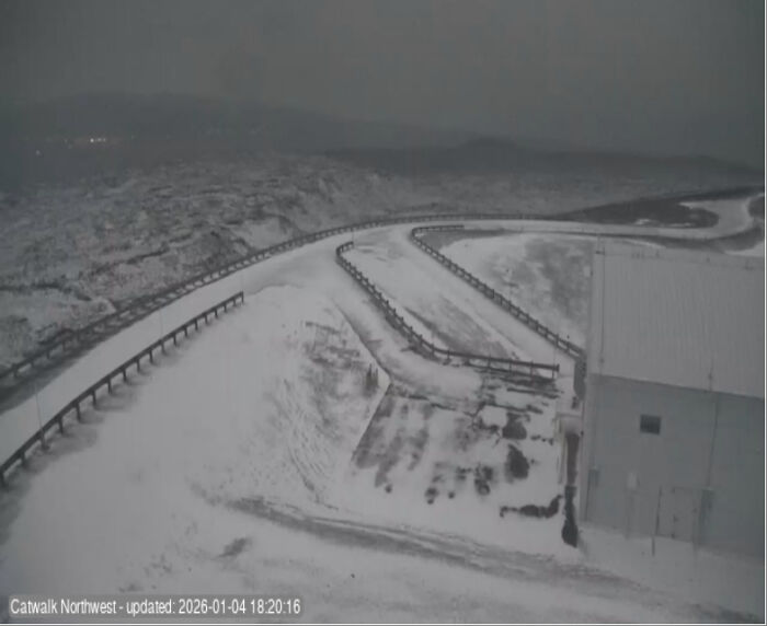 Snow-covered winding road and building in a cozy winter scene capturing the essence of this year's winter atmosphere.