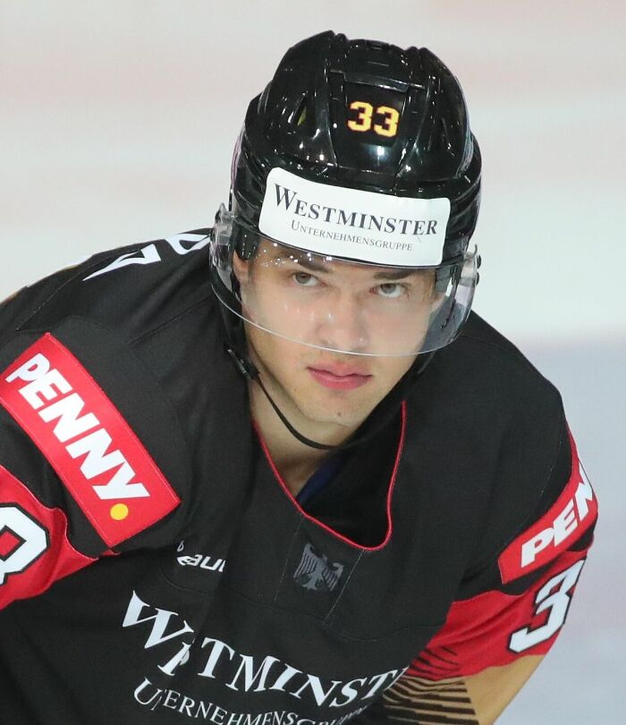 JJ Peterka in black hockey gear, wearing helmet number 33, focused during an intense ice hockey game.