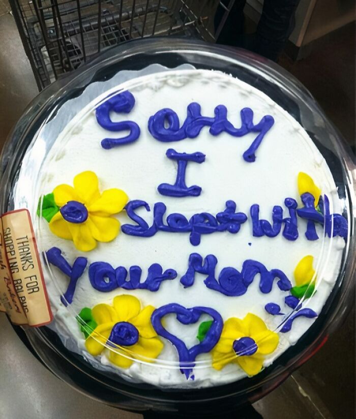 Funny cake with bold purple lettering and yellow flower decorations, capturing honest emotions in a humorous style.
